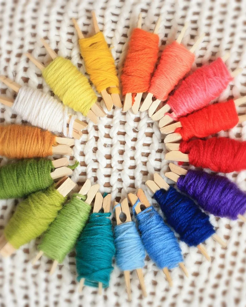 Carretes e hilos de bordar de varios colores dispuestos sobre la mesa de trabajo